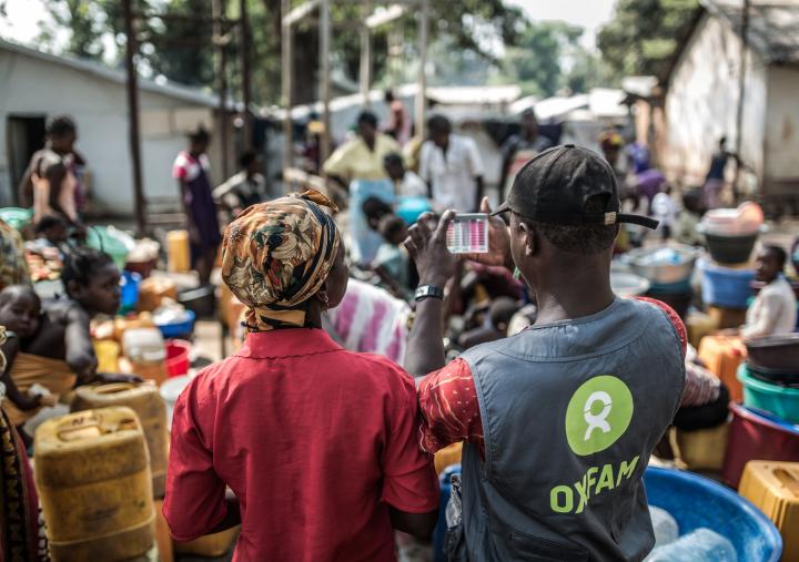 An Oxfam water and sanitation technician with a group of women collecting water at a distribution point built by Oxfam in the displaced camp of Mukassa in Bangui.Credit: Pablo Tosco/Oxfam An Oxfam water and sanitation technician with a group of women collecting water at a distribution point built by Oxfam in the displaced camp of Mukassa in Bangui.Credit: Pablo Tosco/Oxfam