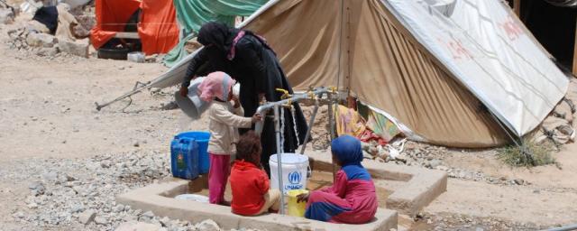 A woman and children gather safe drinking water from the tap Oxfam has installed in Huth IDP camp. Photo: Kate Wiggans/Oxfam A woman and children gather safe drinking water from the tap Oxfam has installed in Huth IDP camp. Photo: Kate Wiggans/Oxfam