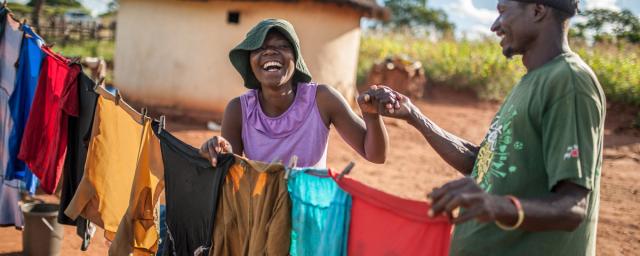 Ulita Mutambo’s husband Muchineripi Sibanda helps her hang up laundry outside their home in Ture Village, Zvishevane region, Zimbabwe. Credit: d'Unienville/Oxfam Ulita Mutambo’s husband Muchineripi Sibanda helps her hang up laundry outside their home in Ture Village, Zvishevane region, Zimbabwe. Credit: d'Unienville/Oxfam