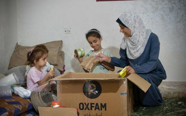 Duaa Mansour and her children are checking the food items in Oxfam food parcel distributed among displaced people due to Israel's war on Gaza. Duaa Mansour and her children are checking the food items in Oxfam food parcel distributed among displaced people due to Israel's war on Gaza.