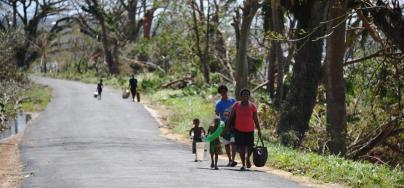 People walking along a road carrying bags